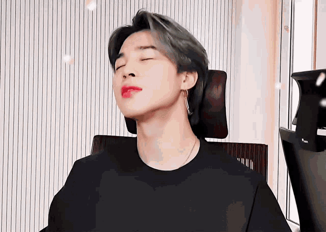 a young man with his eyes closed and red lipstick on his lips