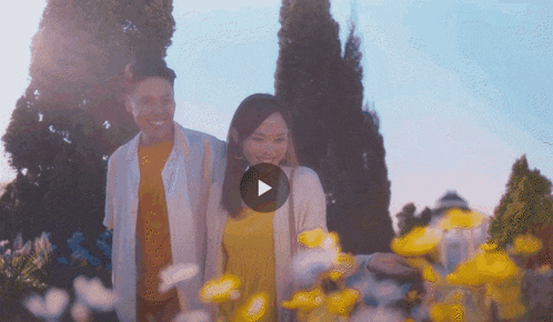 a man and a woman standing next to each other with a play button in the corner