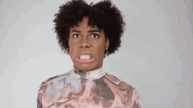 a woman with curly hair is making a funny face with her mouth open