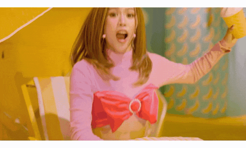 a woman in a pink top with a red bow on her chest