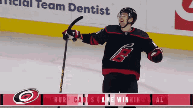 a hockey player is holding a hockey stick in front of an ad for the team dentist
