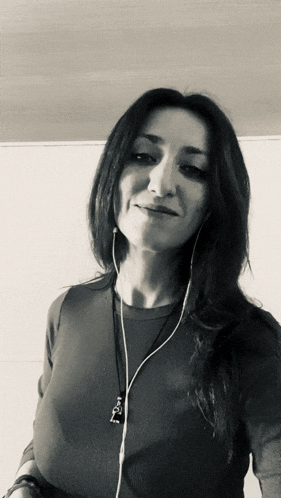 a woman wearing headphones and a necklace with a pendant that says ' i love you '