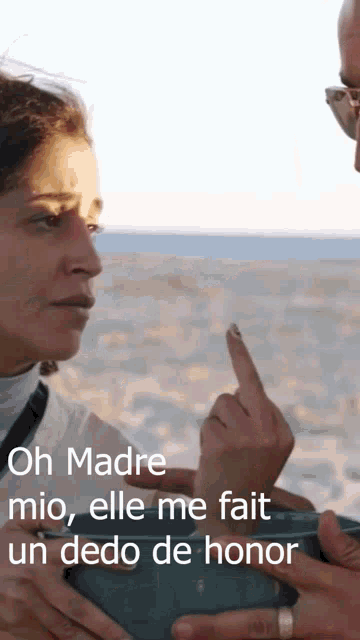 a woman pointing at a man 's finger with the words oh madre mio elle me fait un dedo de honor