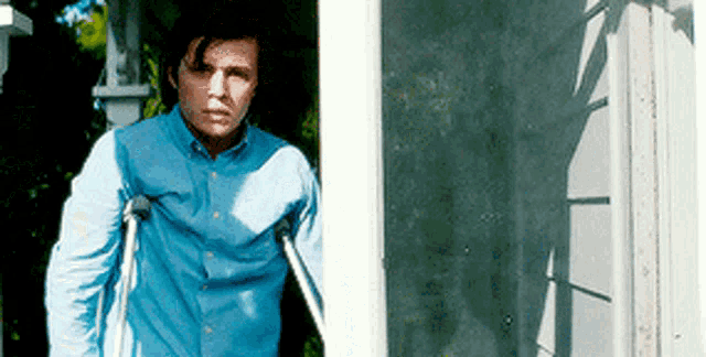 a man with crutches is standing in front of a door