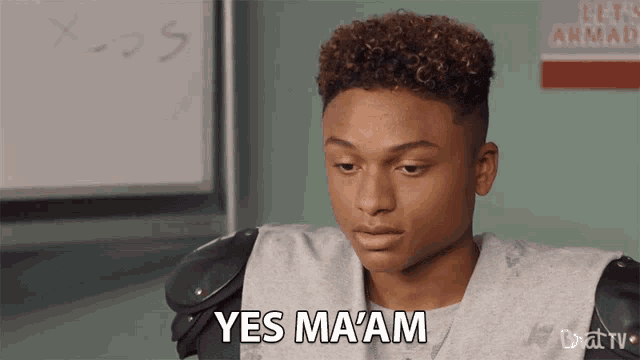 a football player says yes ma am in front of a whiteboard