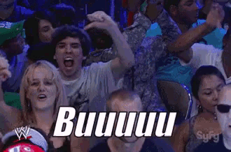 a crowd of people are watching a wrestling match and one of them is shouting buuuu