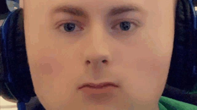 a close up of a person 's face wearing headphones and making a funny face .