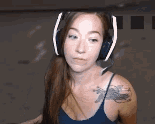 a woman wearing headphones with a tattoo on her shoulder