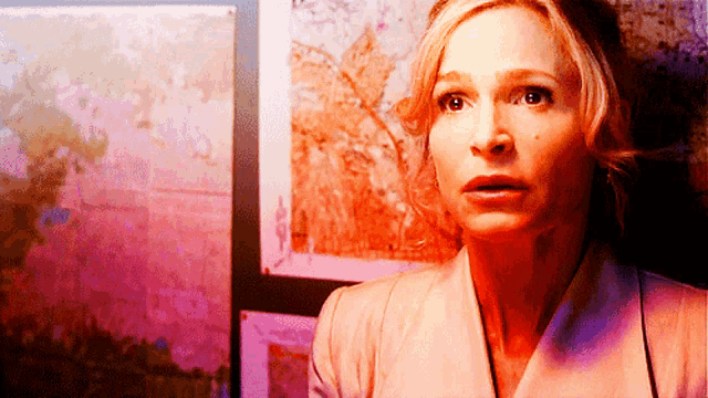 a woman with a surprised look on her face is in front of a painting