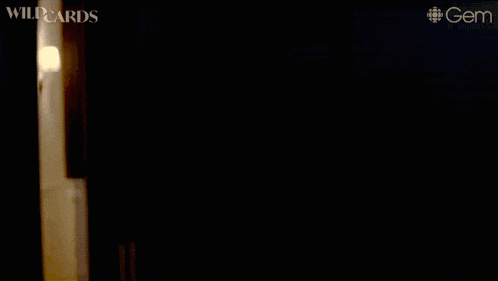 a woman in a black top is standing in a hallway with the word wildcards on the bottom