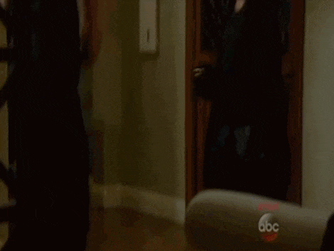 a man and a woman are standing next to each other in a hallway .