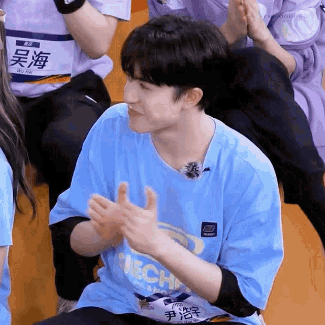 a young man wearing a blue shirt that says tech on it