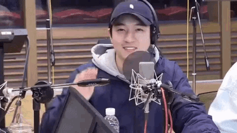 a man wearing a hat and headphones is talking into a microphone