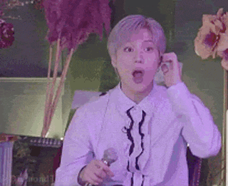 a man is holding a microphone and making a funny face .