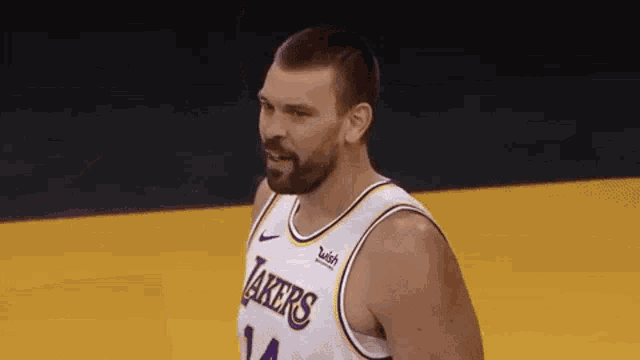 a basketball player with a beard wearing a lakers jersey is standing on a court .