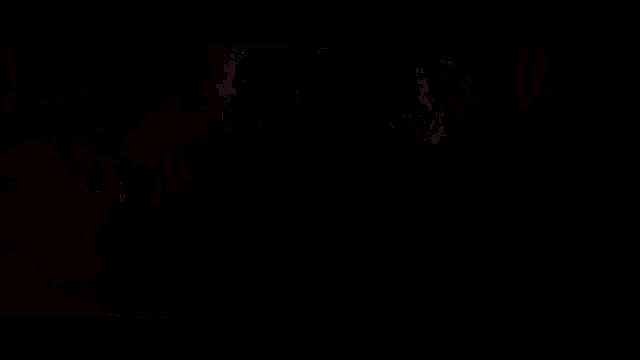 a robot is sitting on top of a pile of lava in a dark room .