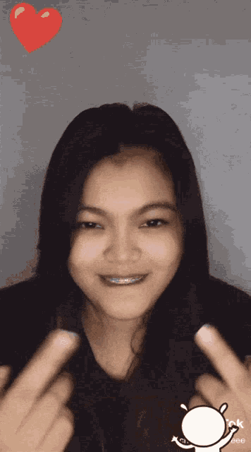 a woman making a heart shape with her fingers and a heart above her head