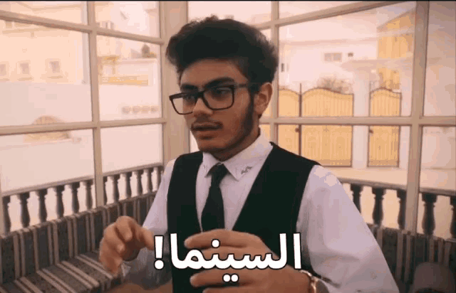 a man wearing glasses and a vest has the word cinema written on his chest
