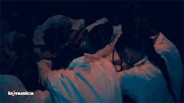a group of people are dancing in a dark room and the words la musica are on the bottom