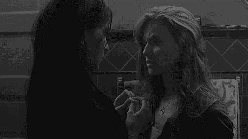 a couple of women are kissing in a bathroom .