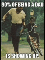 a man is teaching a young boy how to ride a bike