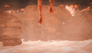 a person 's feet are hanging from a rock in a cave