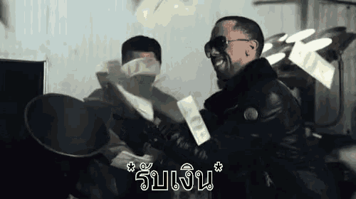 a man in a leather jacket is holding a bunch of money in his hands .