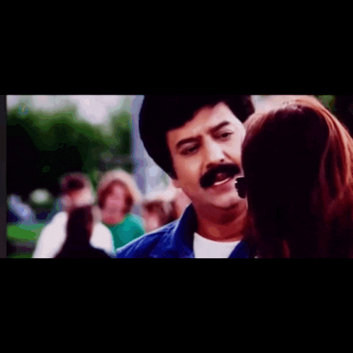 a man with a mustache is talking to a woman and the words nee enna solra are on the bottom