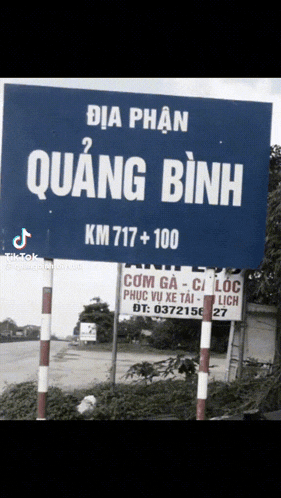 a blue sign that says quang binh km717+100 on it