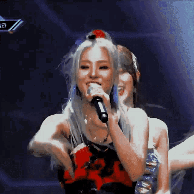 a woman singing into a microphone with the number 21 on the bottom