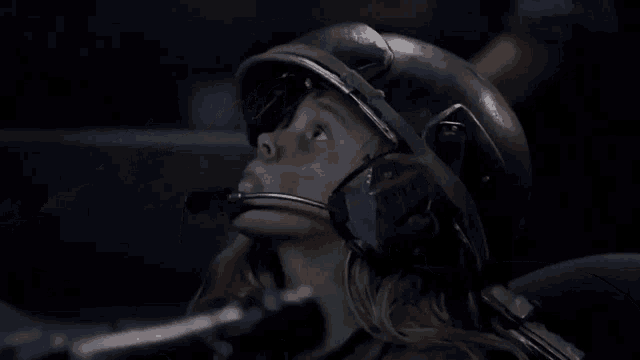 a woman wearing a helmet and headphones looks up at the sky