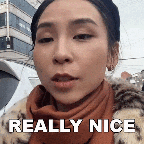 a woman wearing a scarf and a fur coat says " really nice "