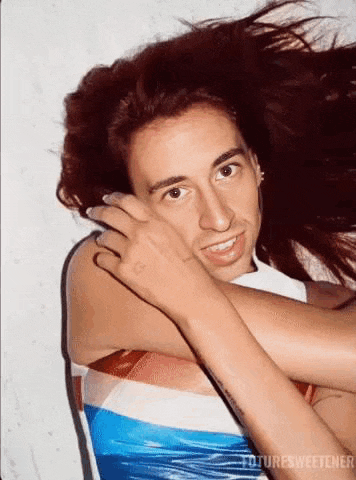 a man is holding a woman 's hair and smiling while laying down .