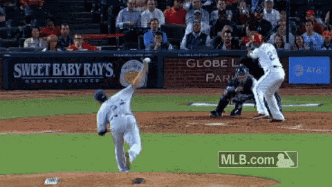 a baseball game is being played in front of a sweet baby ray 's advertisement