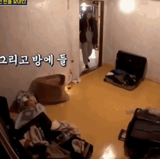 a woman is standing in a room with a suitcase on the floor ..