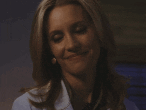 a close up of a woman wearing a lab coat and earrings