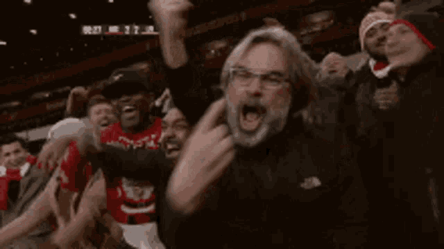 a man with a beard and glasses is making a devil horns sign