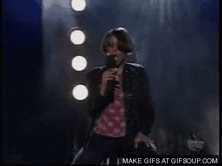 a woman singing into a microphone with a make gifs at gifsoup.com watermark on the bottom