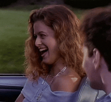 a man and woman are sitting in a car and the woman is smiling at the man .