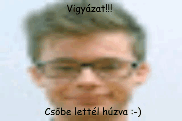 a blurry picture of a man wearing glasses with a caption that says vigyázat !!!