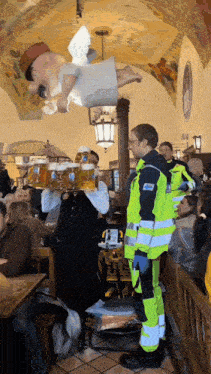 a man carrying a tray of beer stands in front of a crowd