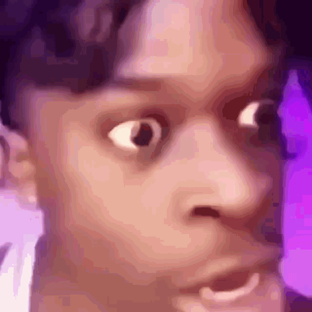 a close up of a person 's face with a purple background .