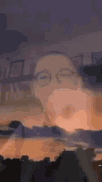 a close up of a person 's face with glasses and a blurred background .
