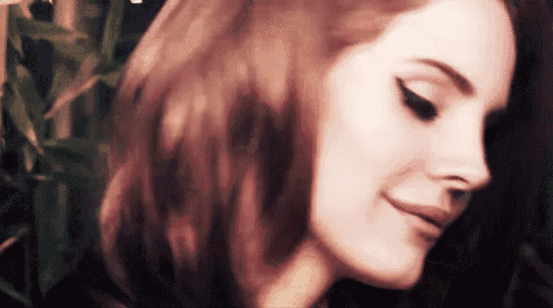 a close up of a woman 's face with her eyes closed and her hair blowing in the wind .