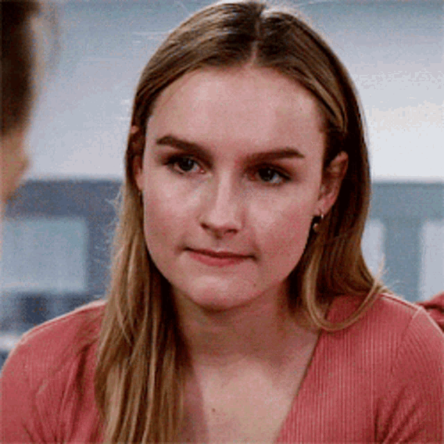 a close up of a woman 's face with a serious look on her face