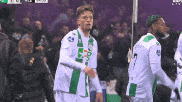 a soccer player wearing a green and white jersey with the number 7 on it