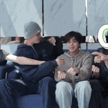 a group of people are sitting on a couch playing a game .