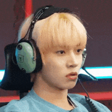 a young man is wearing headphones and a microphone while sitting in a chair .