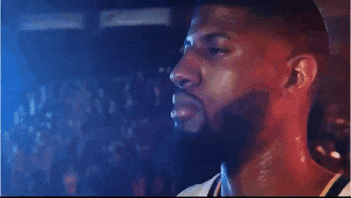 a man with a beard is drinking from a bottle and the words ball game are on the screen