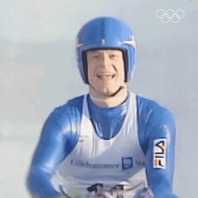 a man wearing a blue helmet and a white fila shirt